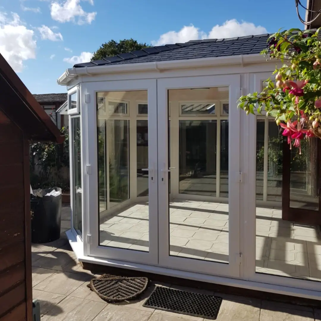 Thermally efficient uPVC conservatory with French doors and a permanent lightweight tiled roof system in Norfolk. By Norfolk Exterior Solutions